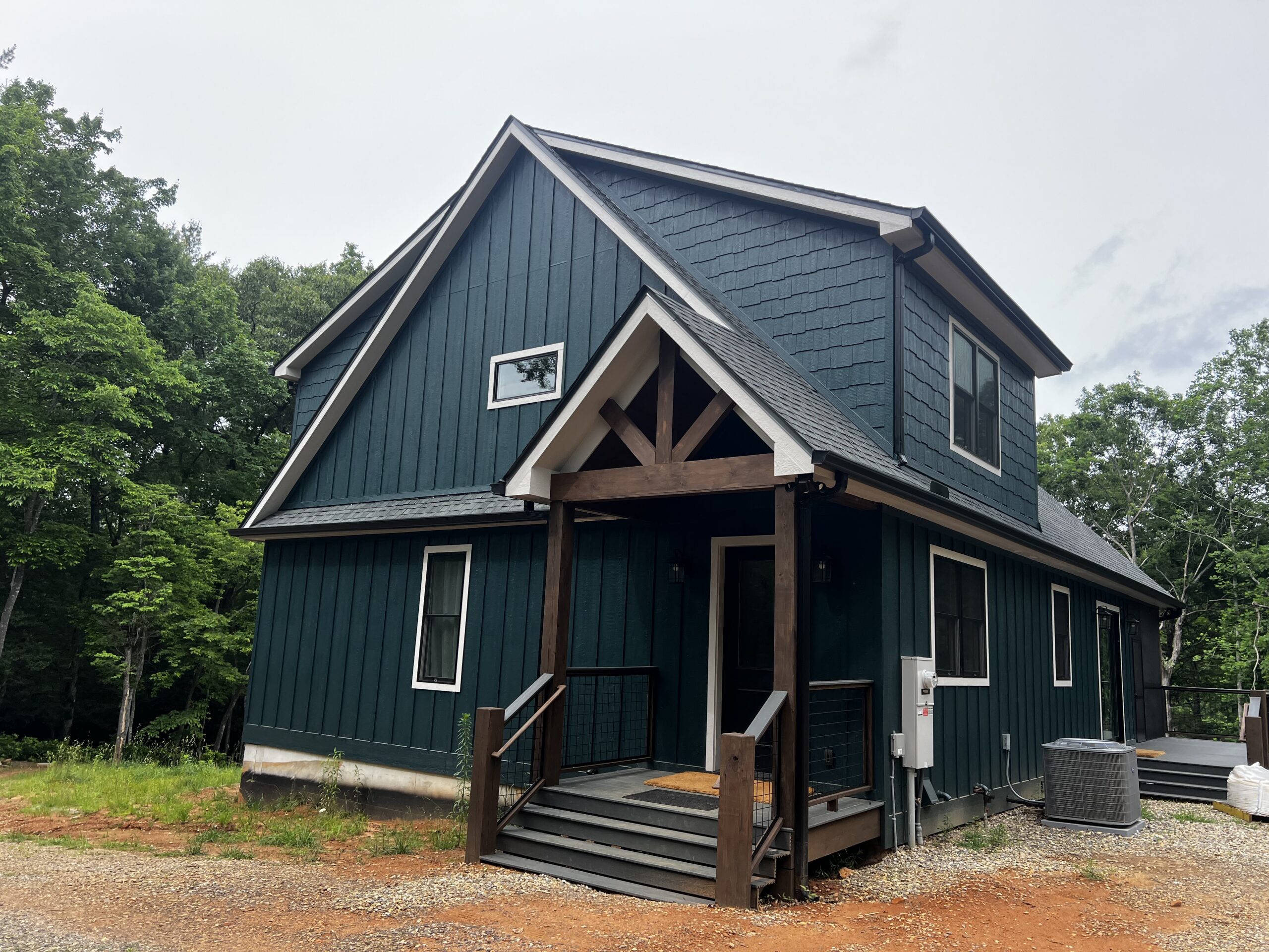 Board and batten mountain farmhouse with a timber framed entry porch Board and batten mountain farmhouse with a timber framed entry porch