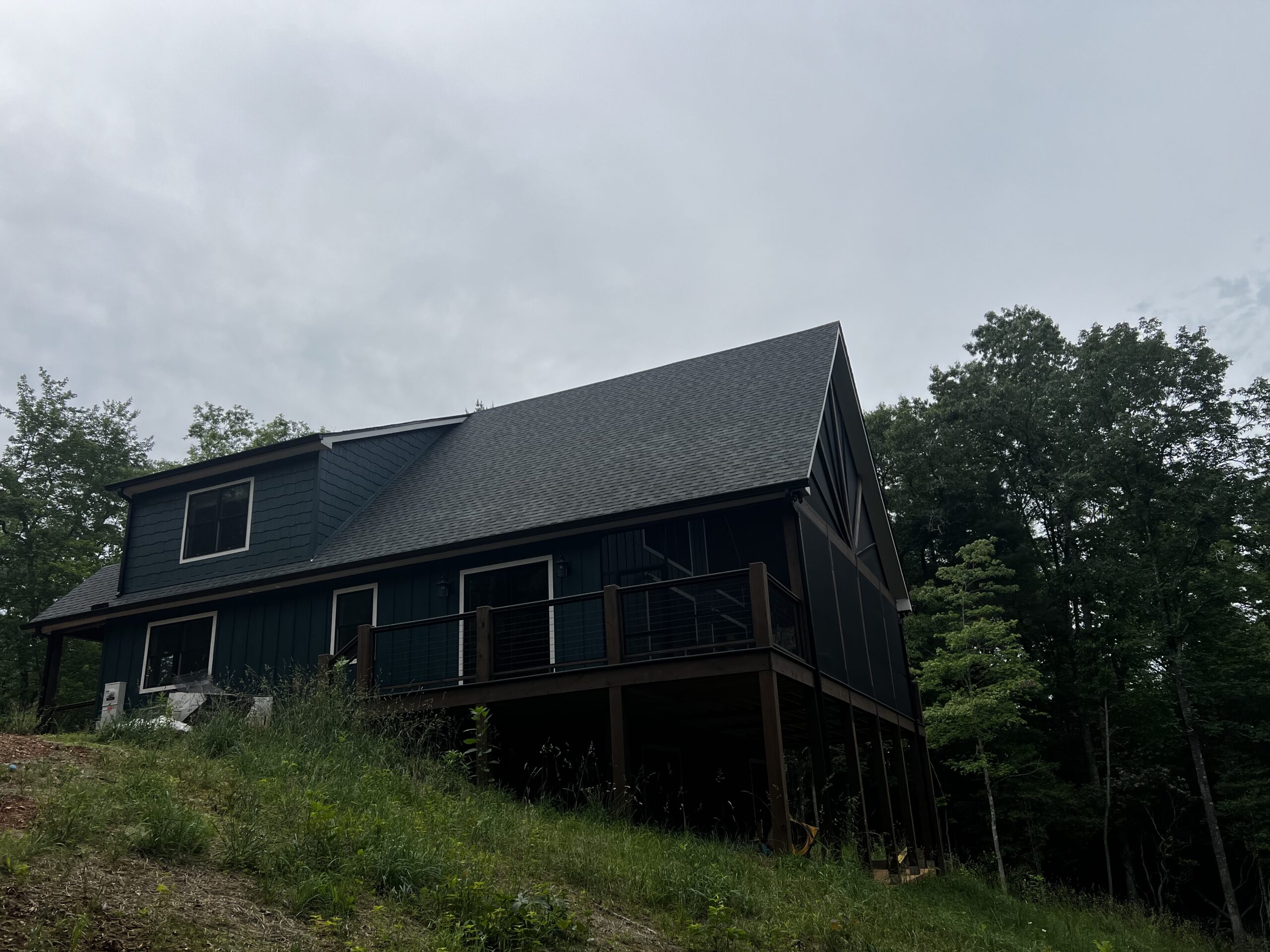 Mountain cabin with a covered deck built on a sloping wooded lot Mountain cabin with a covered deck built on a sloping wooded lot